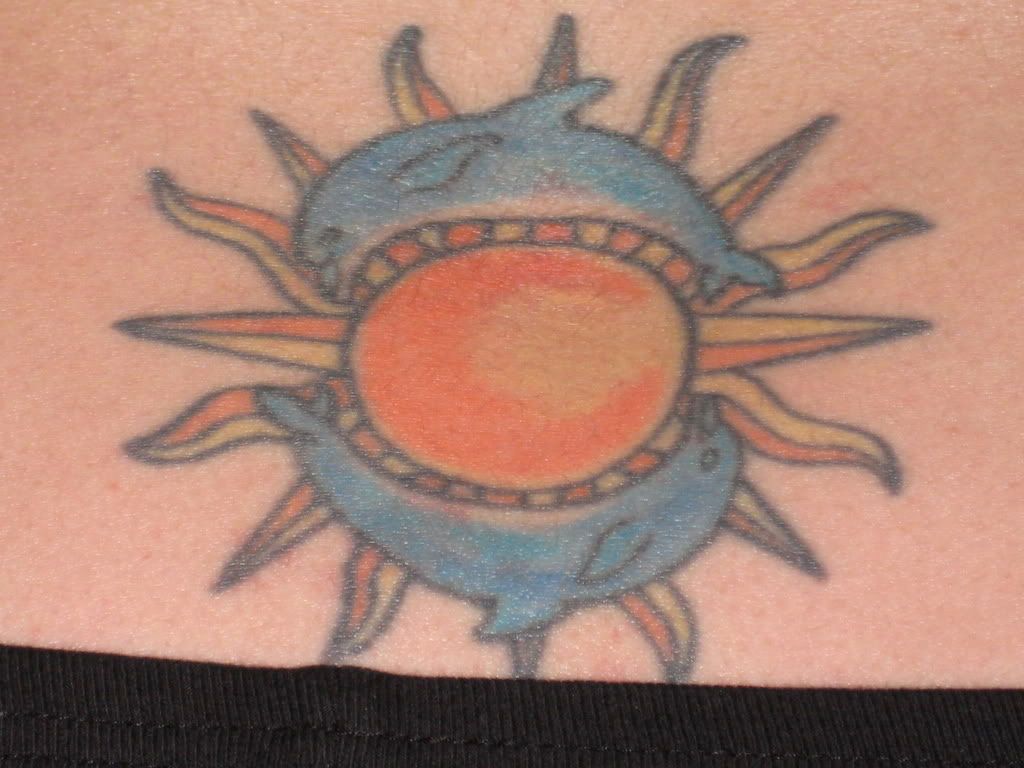a lady bug on my shoulder and dolphins around the sun on my lower back